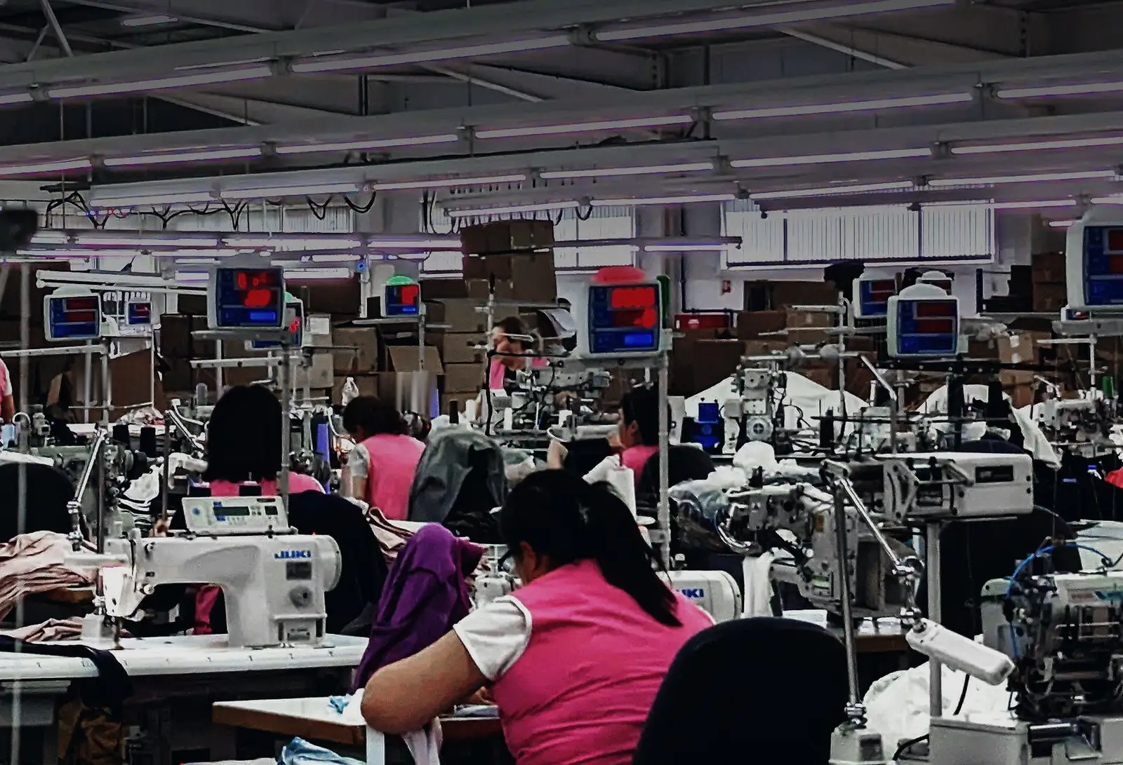 La sala de costura: filas de máquinas y personas cosiendo