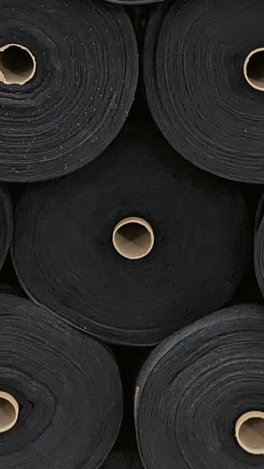 Rollos de tejido negro de algodón orgánico, vistos de cerca